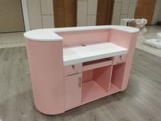 a pink and white counter sitting on top of a hard wood floor next to a wall