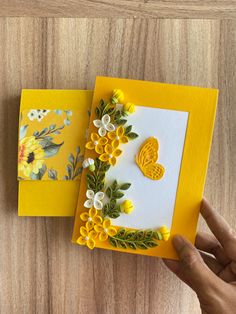 two cards with flowers and butterflies on them, one is yellow and the other is white