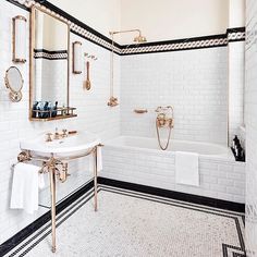 a white bathroom with black and gold accents