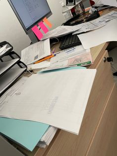 an office desk covered with papers and a computer monitor