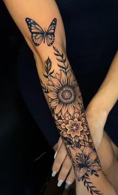 a woman's arm with sunflowers and butterflies on it