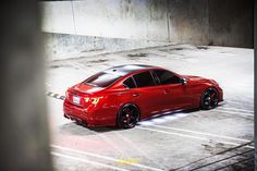 a red car is parked in an empty parking lot