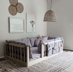 a baby crib in the corner of a room with pictures hanging on the wall