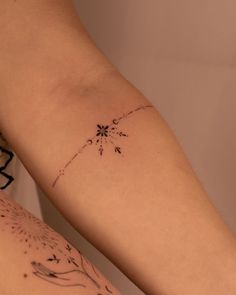 two people with tattoos on their legs, one has a flower and the other has an arrow