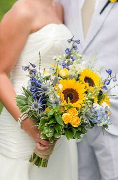 the bride and groom are posing together for a photo with sunflowers in their bouquet