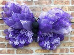 a purple and black wreath on a brick wall