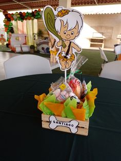 a table topped with a wooden basket filled with candy and candies next to a sign that says sanitao