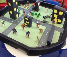 a table with toy figures on it in a play area at a children's museum