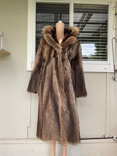 This vintage 70s overcoat is a stunning piece hand crafted from genuine raccoon fur. The long length and rich brown colour make it a timeless addition to any wardrobe. This fur coat was part of a collection I purchased from a family in Northern Europe. It is beautifully crafted, the pelts are soft and supple and well matched. The coat has no labelling. The coat is a size small and features an acetate lining for added comfort. The overcoat style is perfect for layering over any outfit and the rac Brown Long Fur Coat For Fall, Vintage Long Fur Coat For Fall, Brown Long Fur Coat For Winter, Brown Vintage Fur Coat With Faux Fur Trim, Brown Long Coat With Faux Fur Trim, Vintage Fur Coat With Faux Fur Trim, Vintage Faux Fur Mink Coat, Long Overcoat, Northern Europe