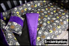 a baby crib with purple and black bedding on it's bottom half