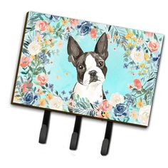 an image of a dog with flowers on it's head hanging from two hooks