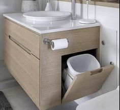 a bathroom with a sink, mirror and toilet paper dispenser in it