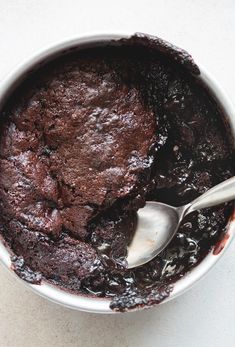 a chocolate cake in a bowl with a spoon