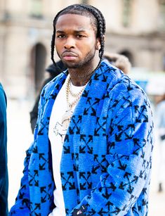 a man with dreadlocks wearing a blue jacket