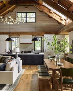 a living room filled with furniture next to a kitchen and dining room table on top of a hard wood floor