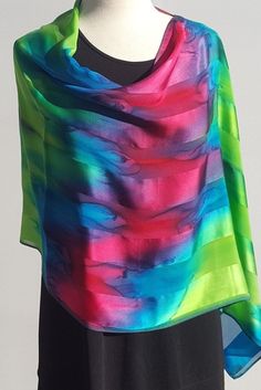 "This sconcho is a versatile piece for everyday wear or for an elegant evening out. It was created out of satin striped silk, then hand painted with jewel tones of every color in the rainbow. It shimmers and looks lovely with so many things. Flowey \"poncho like\" accessory to brighten up your day! Wear over your head with the seam in the back for a symmetrical look or with the seam on the shoulder for an asymmetrical thinning effect as a poncho. The Sconcho can also be put around your neck and Summer Party Satin Silk Scarf, Multicolor Silk Scarf For Evening, Multicolor Satin Silk Scarf For Summer, Summer Silk Scarf With Satin Finish, Multicolor Satin Silk Scarf For Spring, Silk Satin Scarf For Summer Evenings, Summer Multicolor Satin Silk Scarf, Summer Evening Satin Silk Scarf, Multicolor Silk Scarf For Spring Party