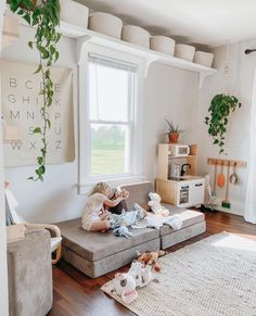 a living room filled with furniture and lots of plants on the windows sills