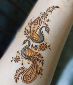 a close up of a person's arm with hennap and flowers on it