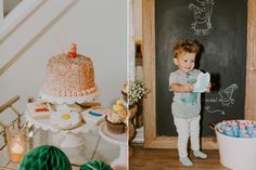 there is a little boy standing in front of a chalkboard and holding a cake