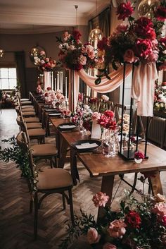 a long table with flowers and candles on it is set for a wedding reception in an elegant setting