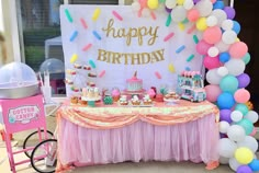 a birthday party with balloons, cake and ice creams on the table in front of an icecream cart