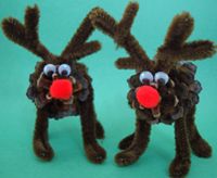 two reindeer made out of pine cones with red noses