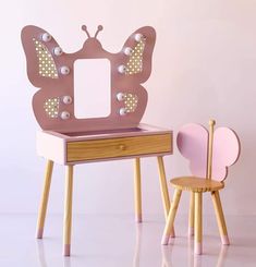 a small wooden table with a mirror on it and a pink chair next to it