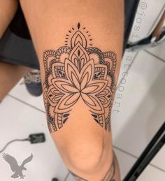 a woman's leg with a tattoo on it and an intricate flower in the center