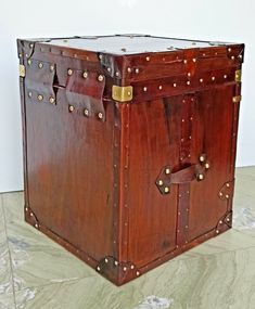 a large wooden trunk sitting on top of a marble floor next to a white wall