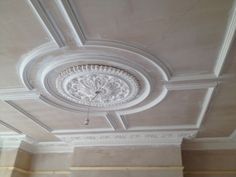 the ceiling in this room is decorated with white paint and decorative moldings on it