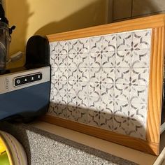 an old radio sitting on top of a counter next to a yellow bowl and other items