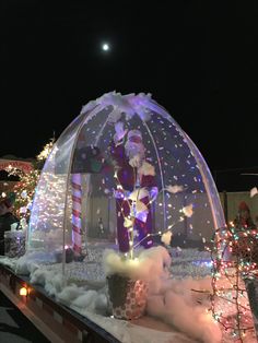 an inflatable santa clause is on display with lights and decorations around it at night