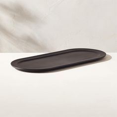 a black plate sitting on top of a white table