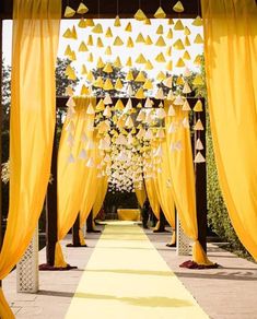 an outdoor ceremony with yellow drapes and decorations