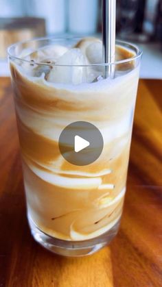 a glass filled with ice cream on top of a wooden table