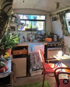 a small kitchen with an oven, dishwasher, and table in it's center