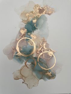 an abstract painting with gold paint and circles on it's surface, against a white background