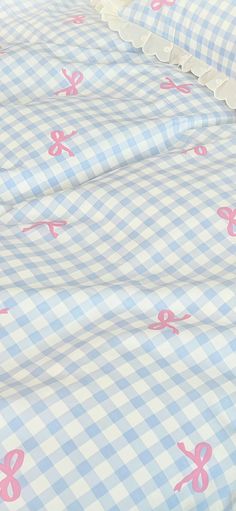 a blue and white checkered bedspread with pink bows on it