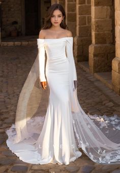 a woman wearing a white wedding dress with long sleeves and a veil on her head