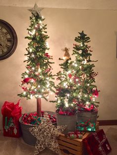 two small christmas trees with presents under them