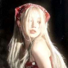 a woman with long blonde hair wearing a red bandana and posing for the camera