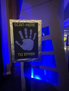 there is a sign that says scan here to enter with blue lights in the background