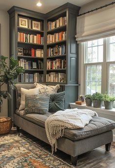 a living room filled with furniture and bookshelves next to a window covered in plants