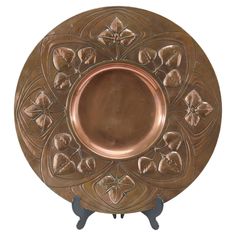 an ornately designed copper plate with flowers on it