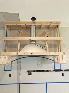 a stove that is being built in a room with blue tape on the floor and walls