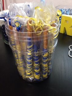 a plastic cup filled with candy sticks on top of a table