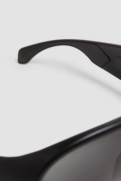 The Cloche reinterprets classic pilot sunglasses with a rounded mask shape that nods to the slopes. The eyewear pairs black frames with dark gray lenses, accentuating its futuristic oval silhouette. Classic Matte Black Shield Sunglasses With Uva Protection, Matte Black Aviator Shield Sunglasses With Uva Protection, Matte Black Aviator Shield Sunglasses With Anti-reflective, Black Shield Sunglasses With Mirrored Lenses, Black Aviator Shield Sunglasses With Mirrored Lenses, Classic Black Shield Sunglasses, Modern Shield Sunglasses With Gradient Lenses, Futuristic Black Sunglasses With Uva Protection, Modern Matte Black Aviator Shield Sunglasses