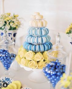 blue and yellow desserts are stacked on top of each other in glass vases