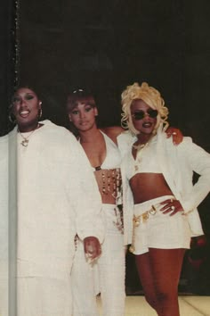 three women standing next to each other in white outfits