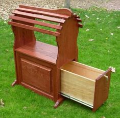 a wooden bench sitting in the grass next to a tree